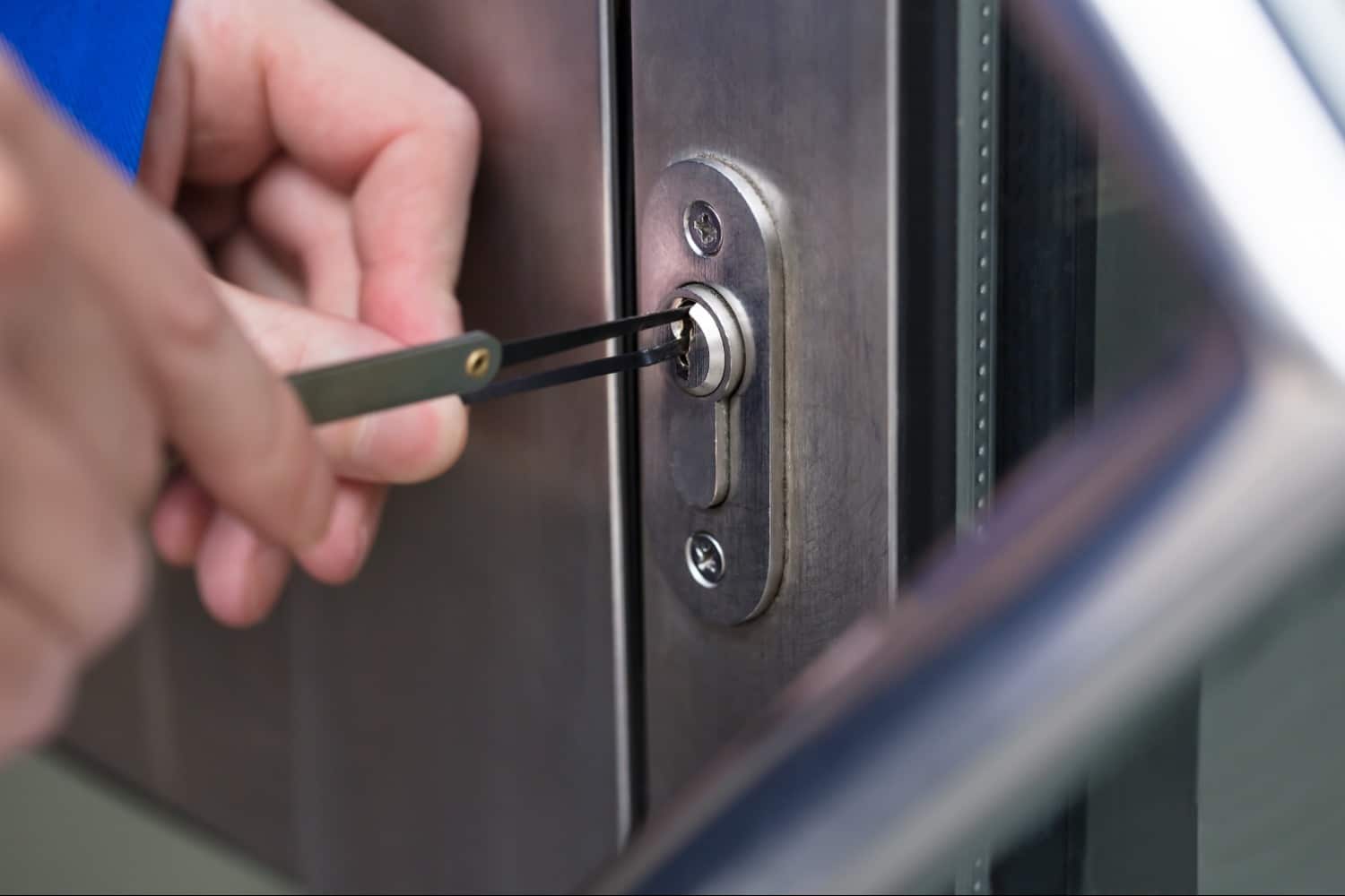 locksmith using locksmithing tools to open business locked door